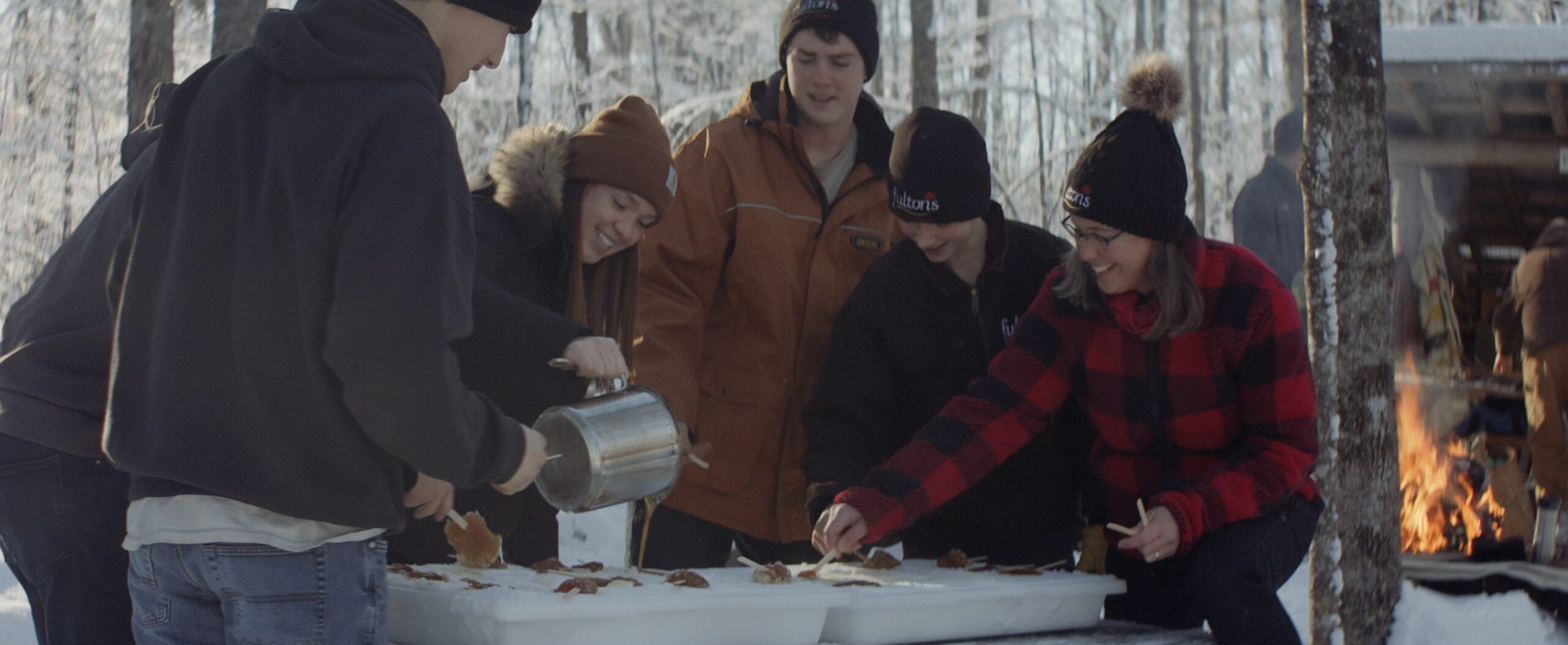 Une famille canadienne dégustant de la tire d'érable maison