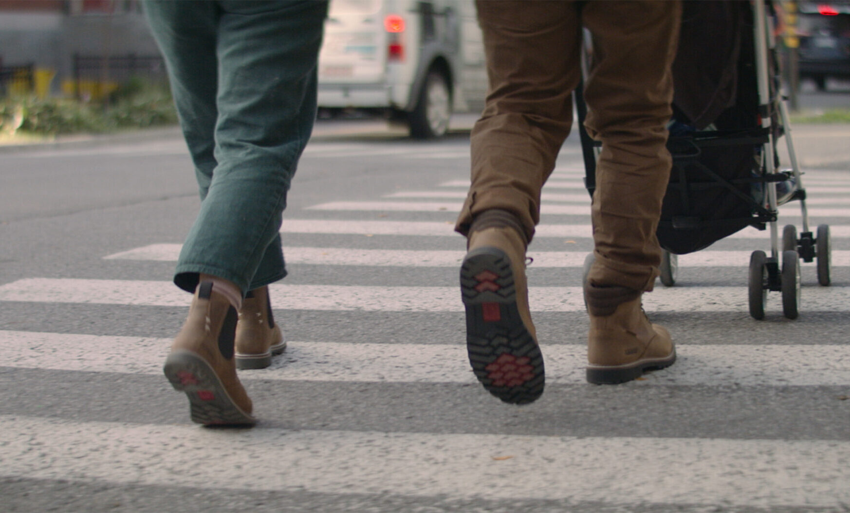 Une jeune famille traversant la rue en portant des chaussures robustes