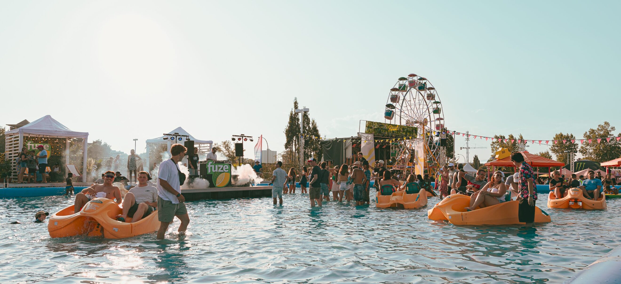 Plan large du bassin géant du festival Parasol Gatineau par une soirée ensoleillée avec des festivaliers heureux